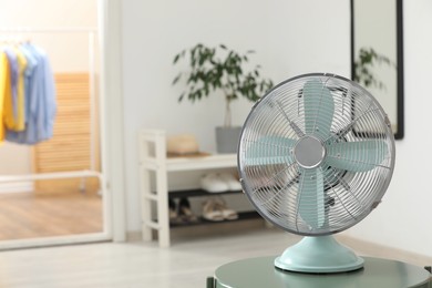 Photo of Modern electric fan on table in room, space for text