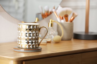 Photo of Mug of hot drink with stylish cup coaster on dressing table indoors. Space for text