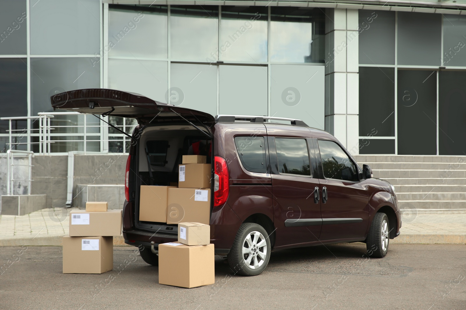 Photo of Courier car with packages parked near office building