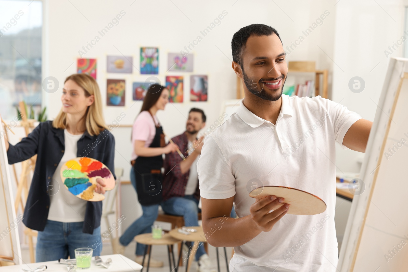 Photo of Group of students attending painting class in studio. Creative hobby