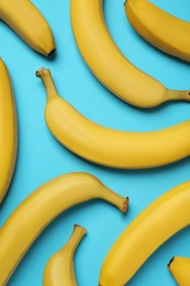 Ripe yellow bananas on turquoise background, flat lay