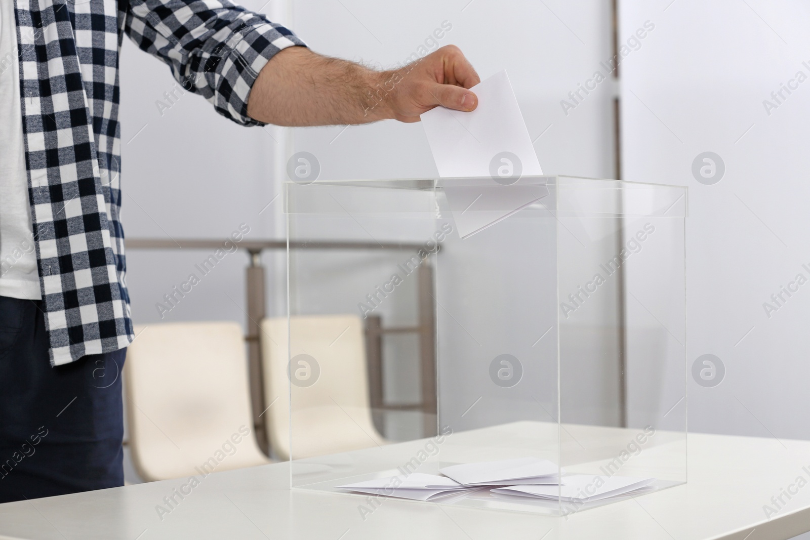 Photo of Man putting his vote into ballot box at polling station, closeup. Space for text