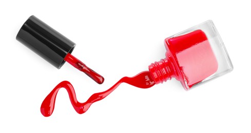 Overturned bottle of red nail polish and brush isolated on white, top view