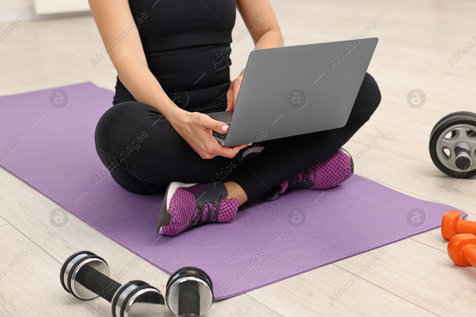 Photo of Online fitness trainer. Woman watching tutorial on laptop indoors, closeup