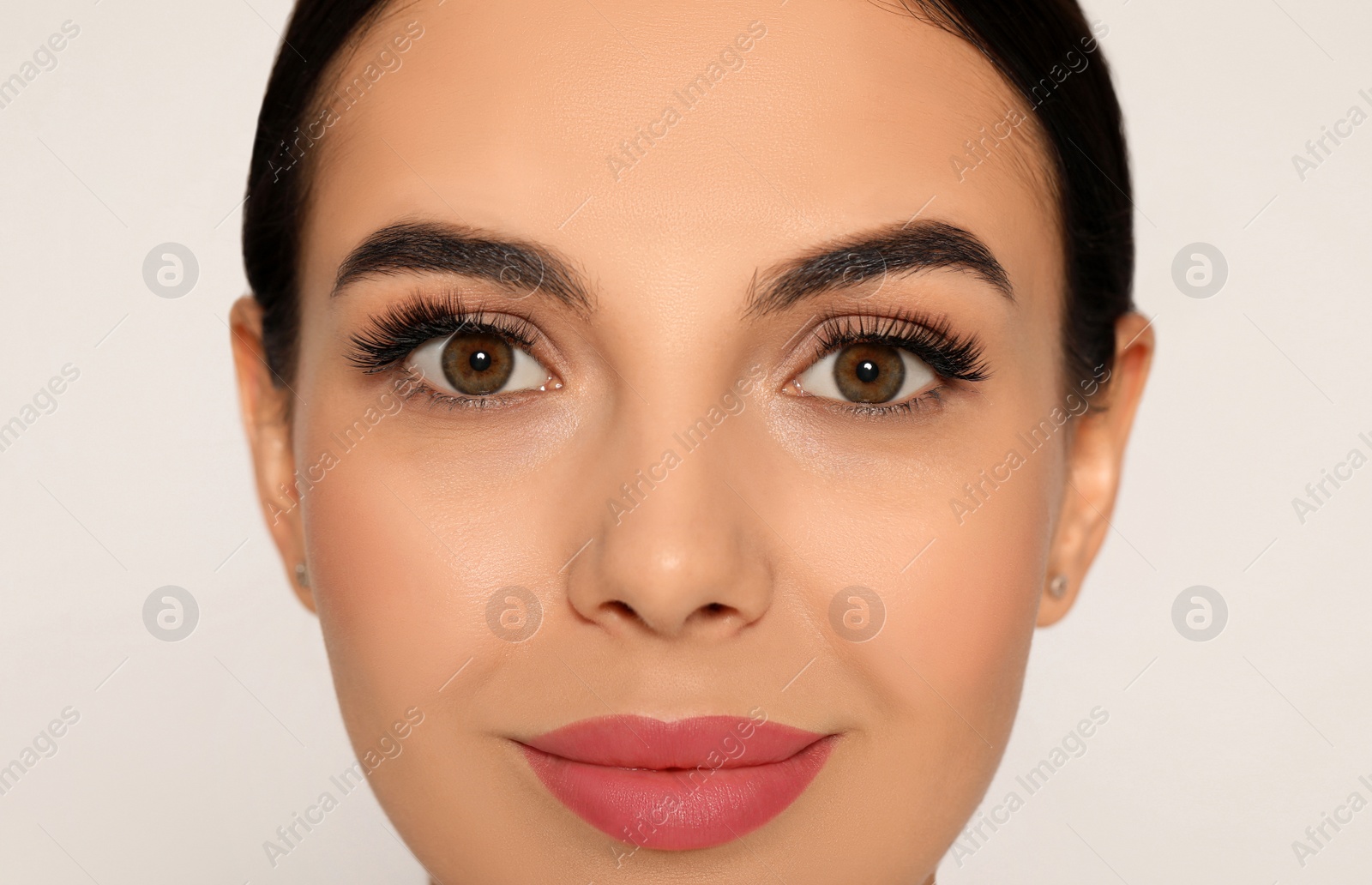 Photo of Beautiful young woman with long eyelashes on light background, closeup