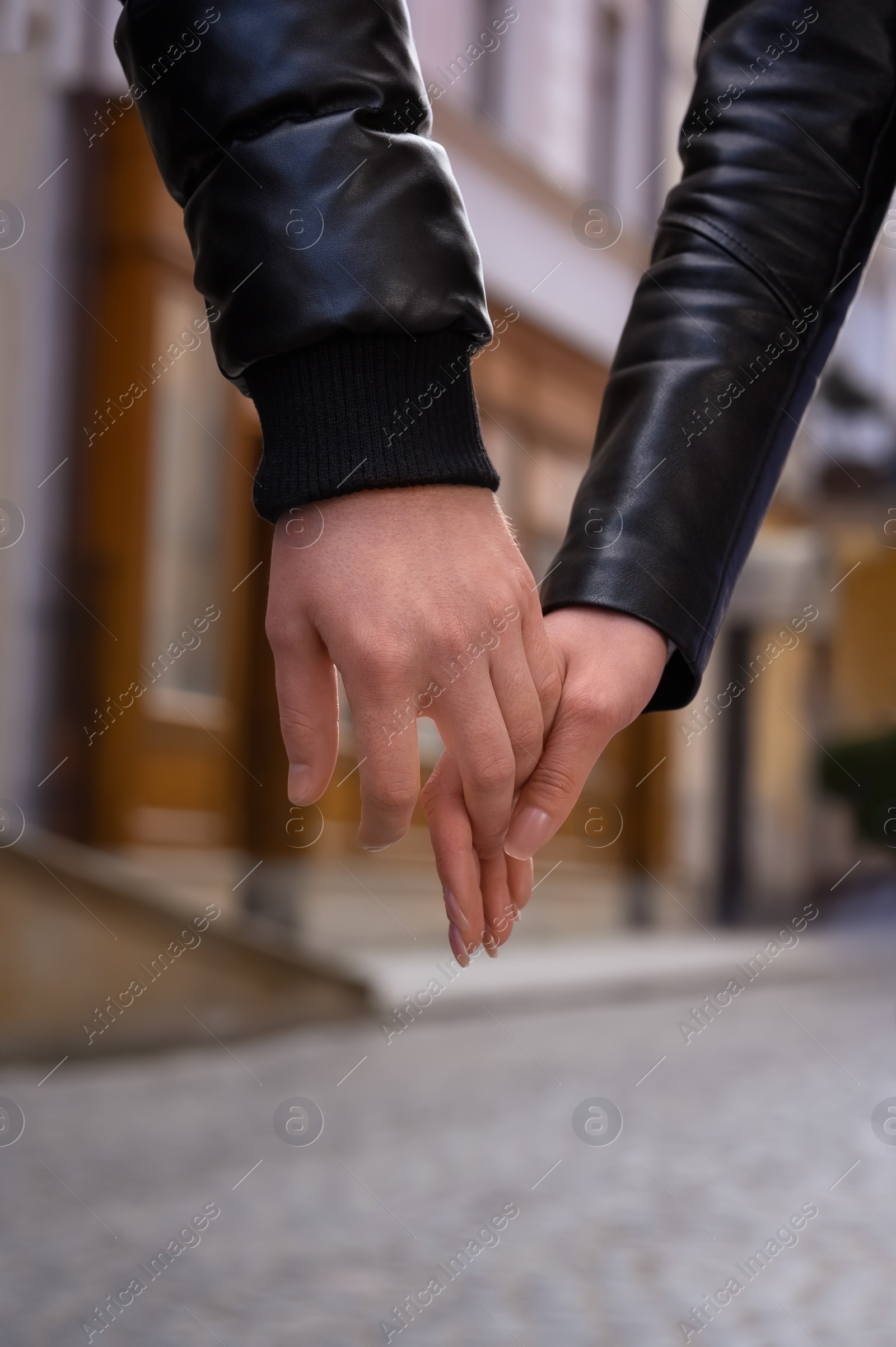 Photo of Lovely couple holding hands together outdoors, closeup. Romantic date