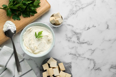 Delicious tofu cheese with parsley and spoon on white marble table, flat lay. Space for text