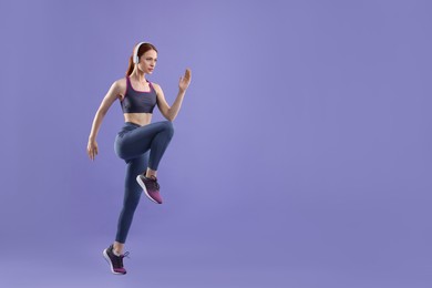 Photo of Woman in sportswear running on violet background, space for text