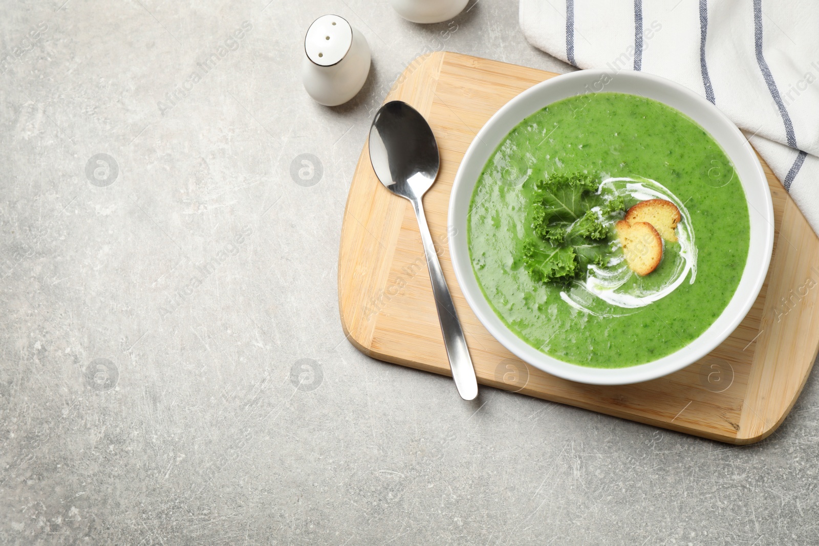 Photo of Tasty kale soup served on light grey table, flat lay. Space for text