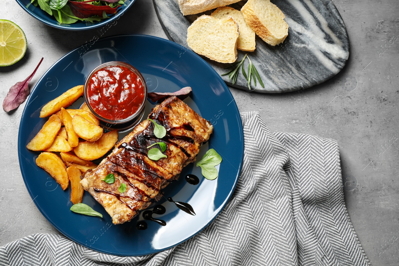 Photo of Delicious grilled ribs served on light grey table, flat lay