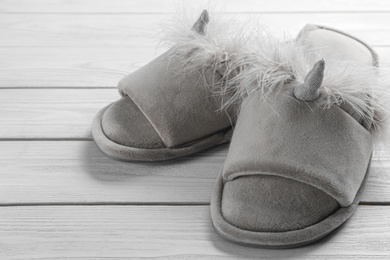 Photo of Pair of stylish soft slippers on white wooden background, closeup