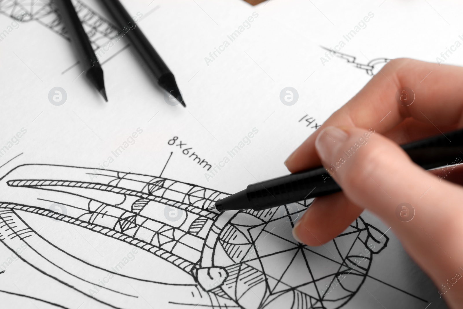 Photo of Jeweler drawing sketch of elegant ring on paper, closeup