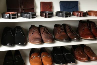 Photo of White shelving unit with different leather shoes and accessories