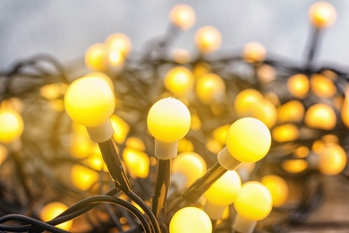 Glowing Christmas lights, closeup. Beautiful festive illumination