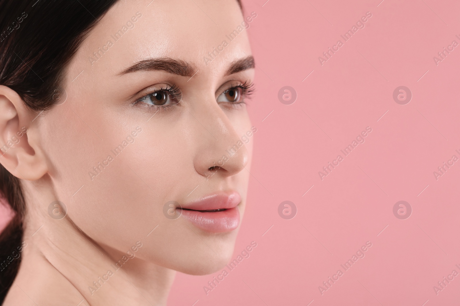 Photo of Beautiful young woman with healthy skin on pink background, closeup. Space for text