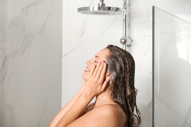 Image of Beautiful young woman taking shower at home