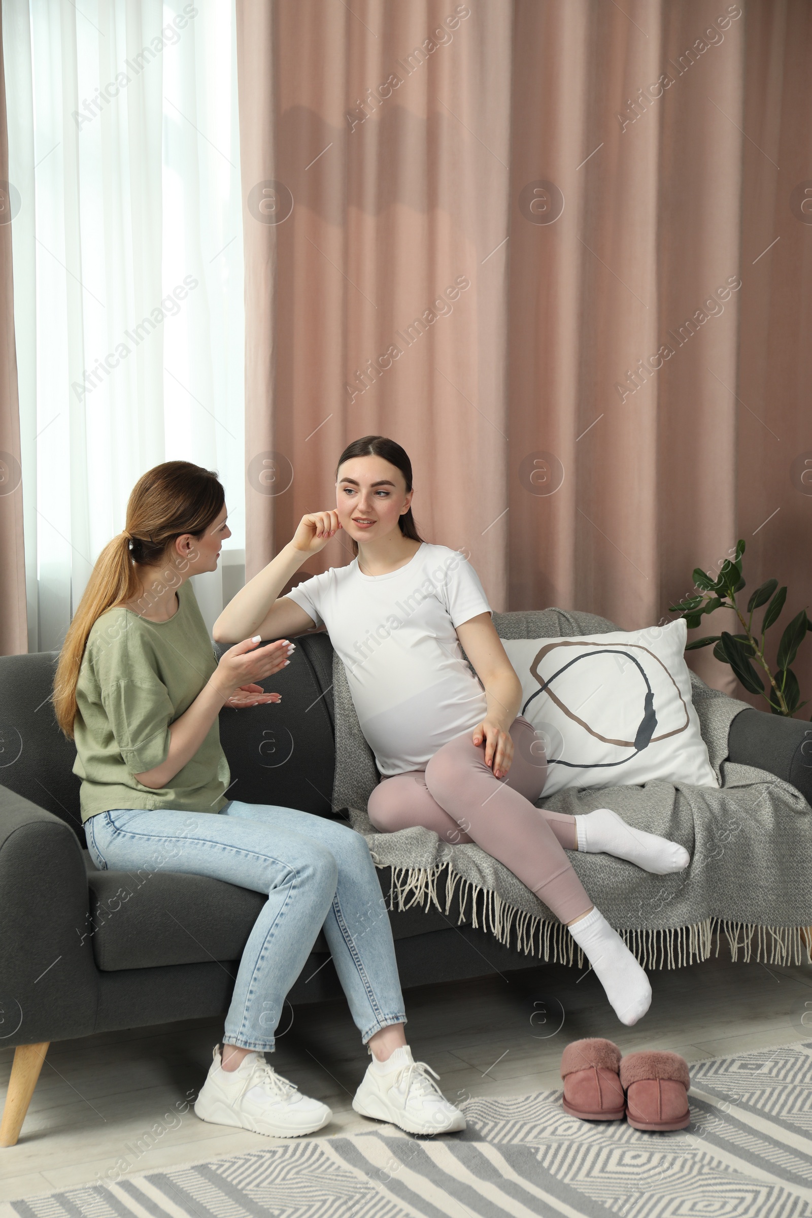 Photo of Doula working with pregnant woman on sofa at home. Preparation for child birth