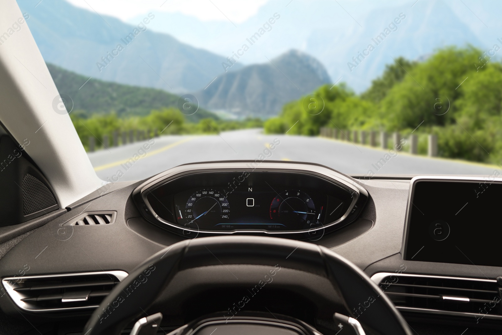 Image of Dashboard with speedometer behind steering wheel inside car