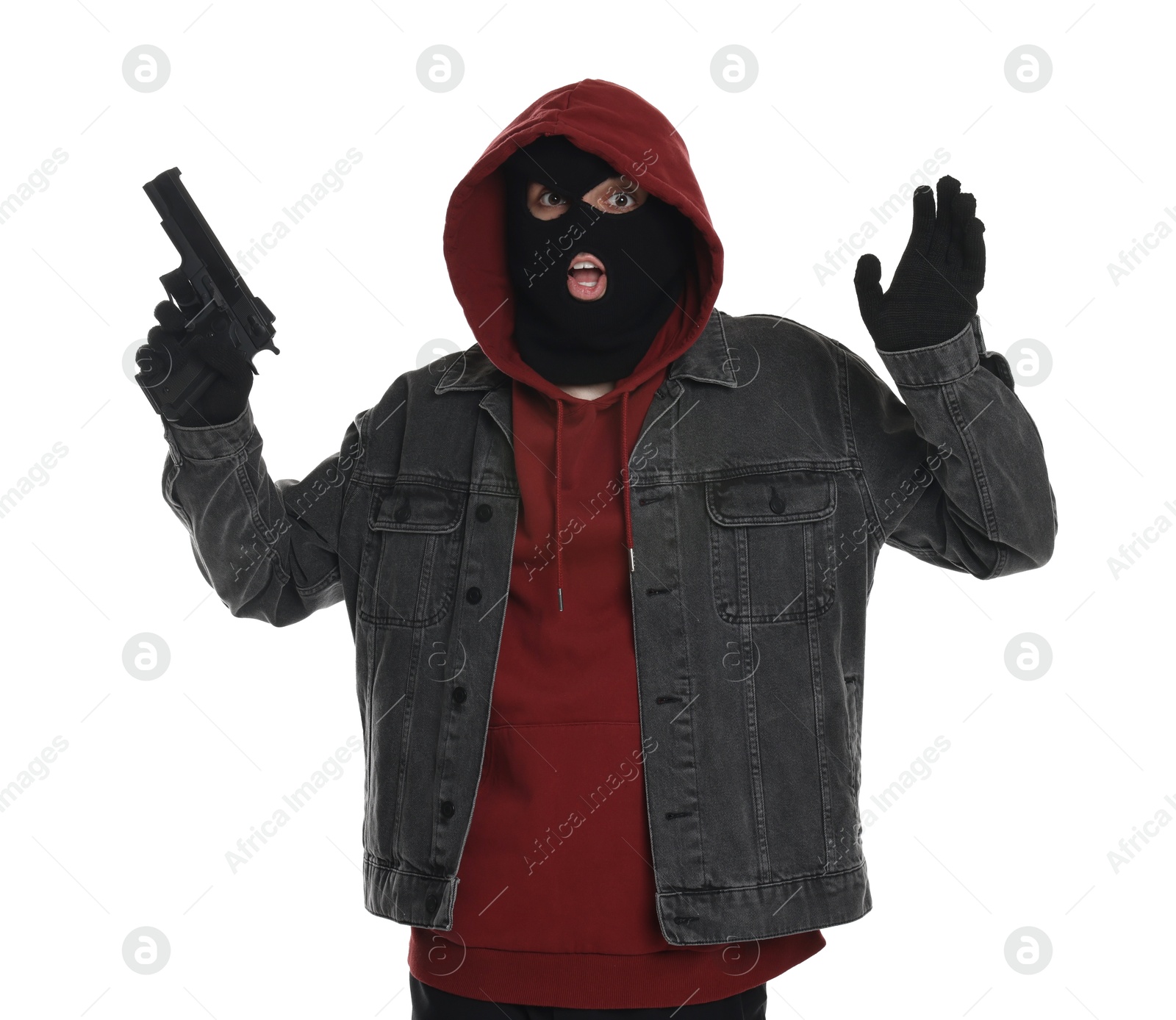 Photo of Emotional thief in balaclava raising hands with gun on white background