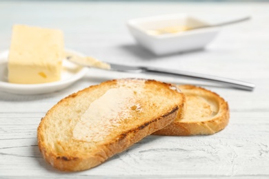 Toasted bread with butter on wooden background