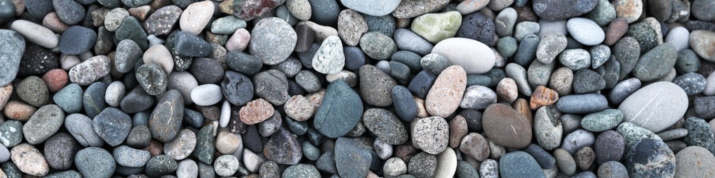 Many different pebbles as background, top view. Banner design