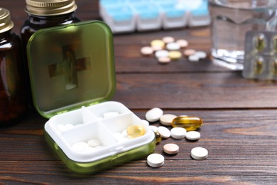 Pill box with medicaments on wooden table. Space for text