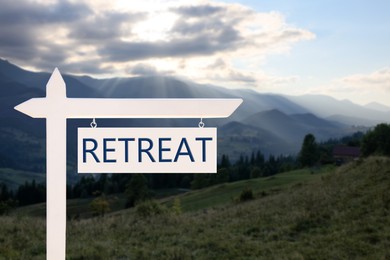 Image of Wooden sign with word Retreat and beautiful view of mountain landscape