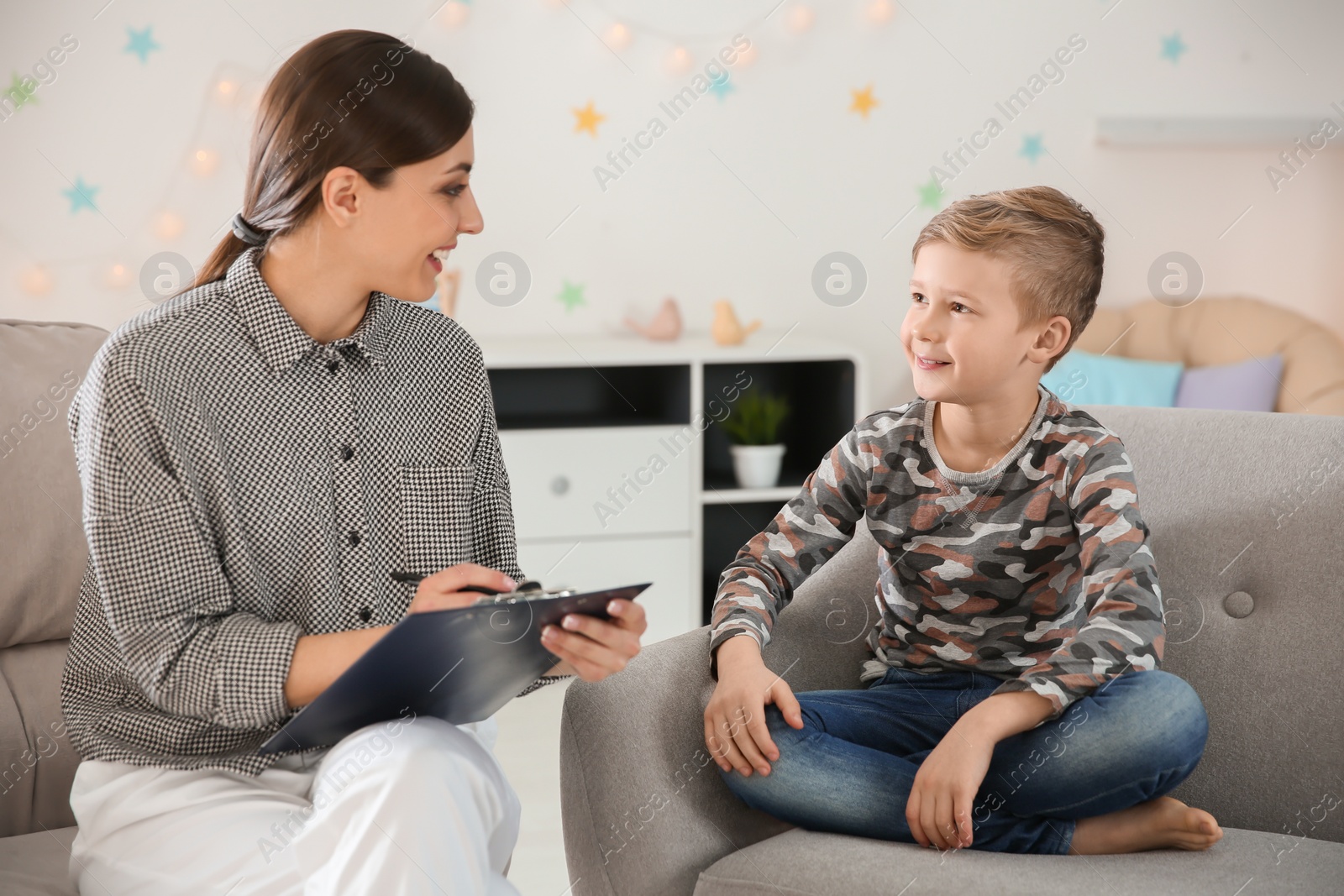 Photo of Female psychologist working with cute little boy in office