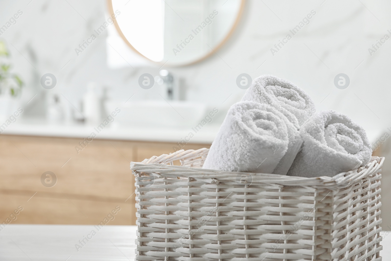 Photo of Rolled fresh towels in bathroom, closeup. Space for text