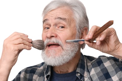 Photo of Senior man with mustache holding blade and brush on white background