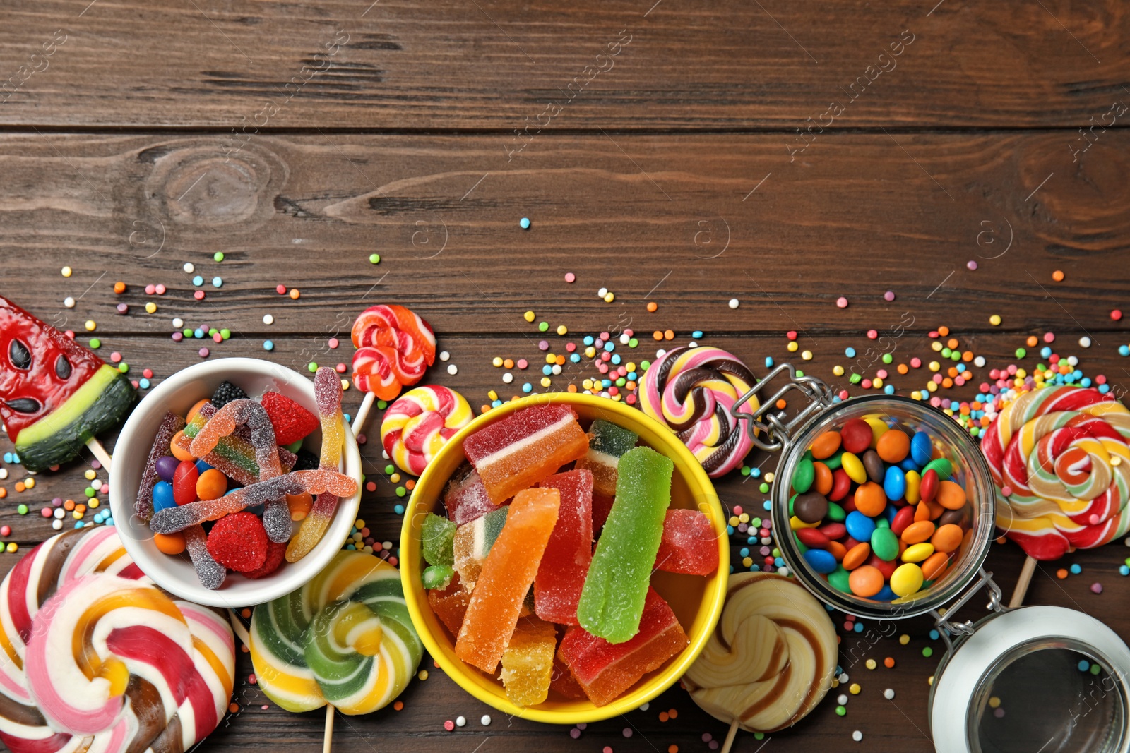 Photo of Flat lay composition with different yummy candies and space for text on wooden background