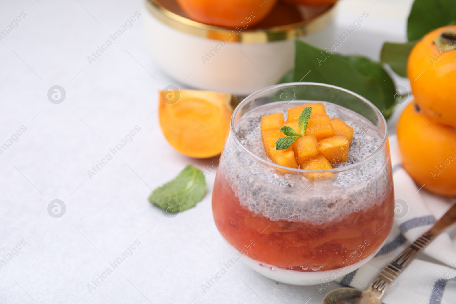 Photo of Delicious dessert with persimmon and chia seeds on table, closeup