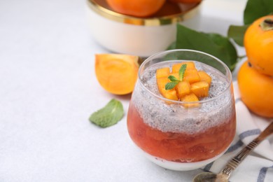 Delicious dessert with persimmon and chia seeds on table, closeup