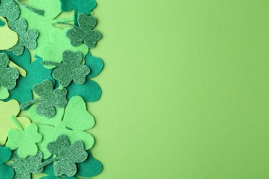 St. Patrick's day. Decorative clover leaves on green background, top view. Space for text