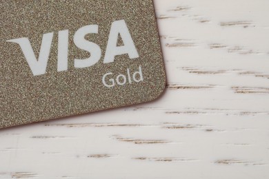 Photo of MYKOLAIV, UKRAINE - FEBRUARY 22, 2022: Visa credit card on white wooden table, closeup. Space for text