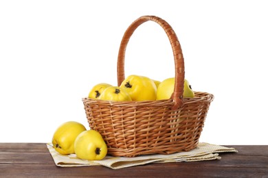 Basket with delicious fresh ripe quinces on wooden table against white background