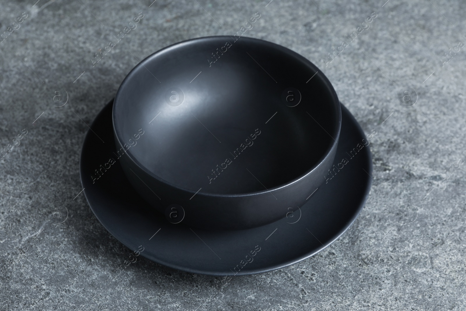 Photo of Empty clean ceramic dishware on grey table, closeup