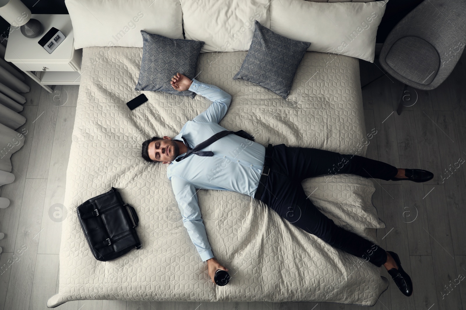 Photo of Exhausted businessman in office wear sleeping on bed at home after work, above view