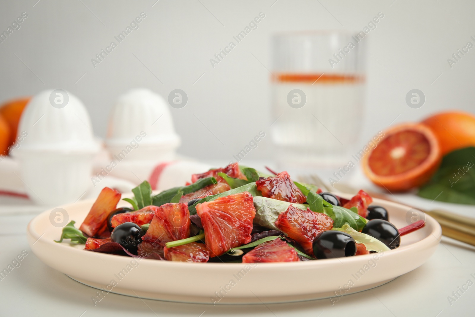 Photo of Delicious salad with sicilian orange on white table, closeup