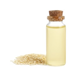Photo of Glass bottle with fresh sesame oil and seeds isolated on white