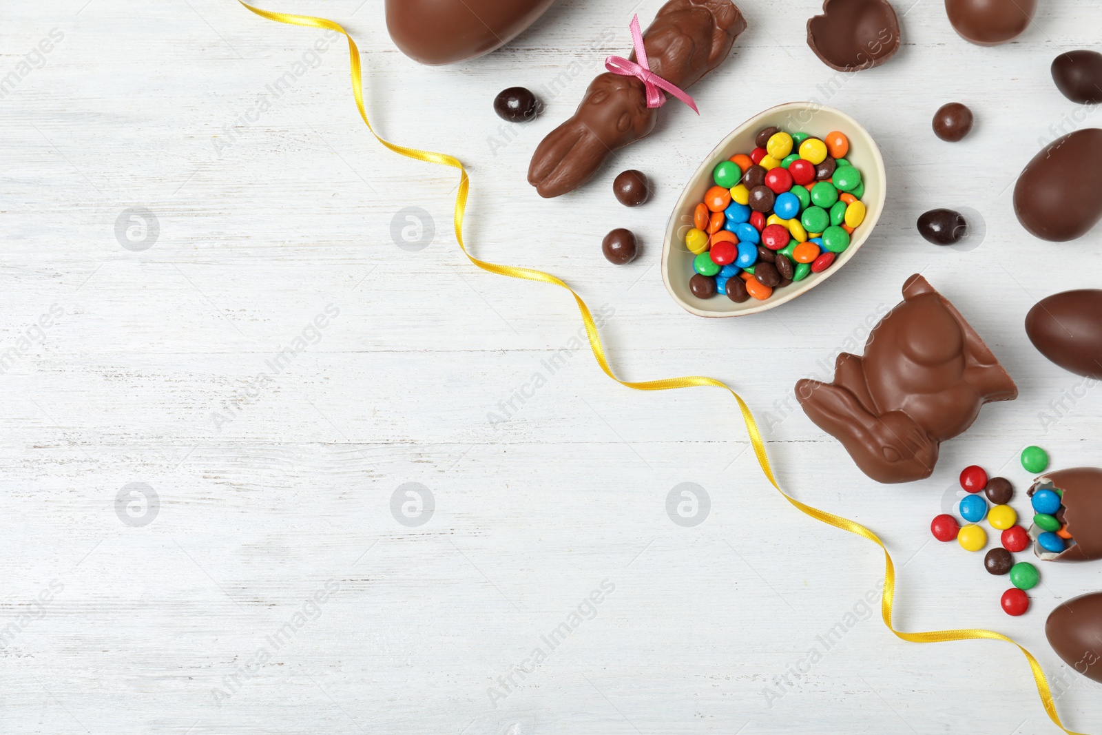 Photo of Flat lay composition with chocolate Easter eggs and space for text on wooden background