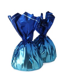 Delicious candies in blue wrappers on white background