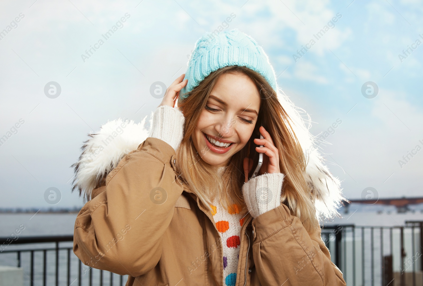 Photo of Young woman talking on mobile phone outdoors