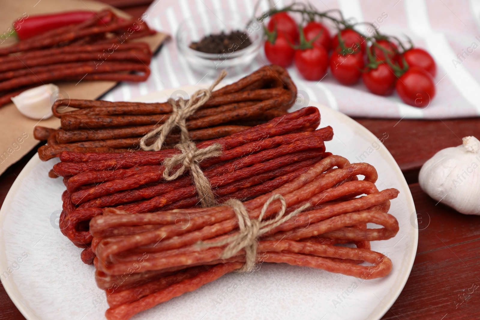 Photo of Bundles of delicious kabanosy on wooden table