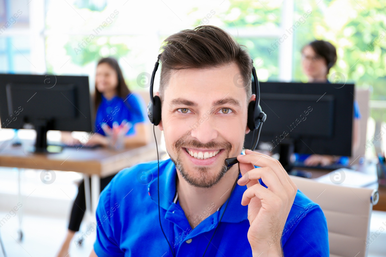 Photo of Male technical support operator with headset at workplace
