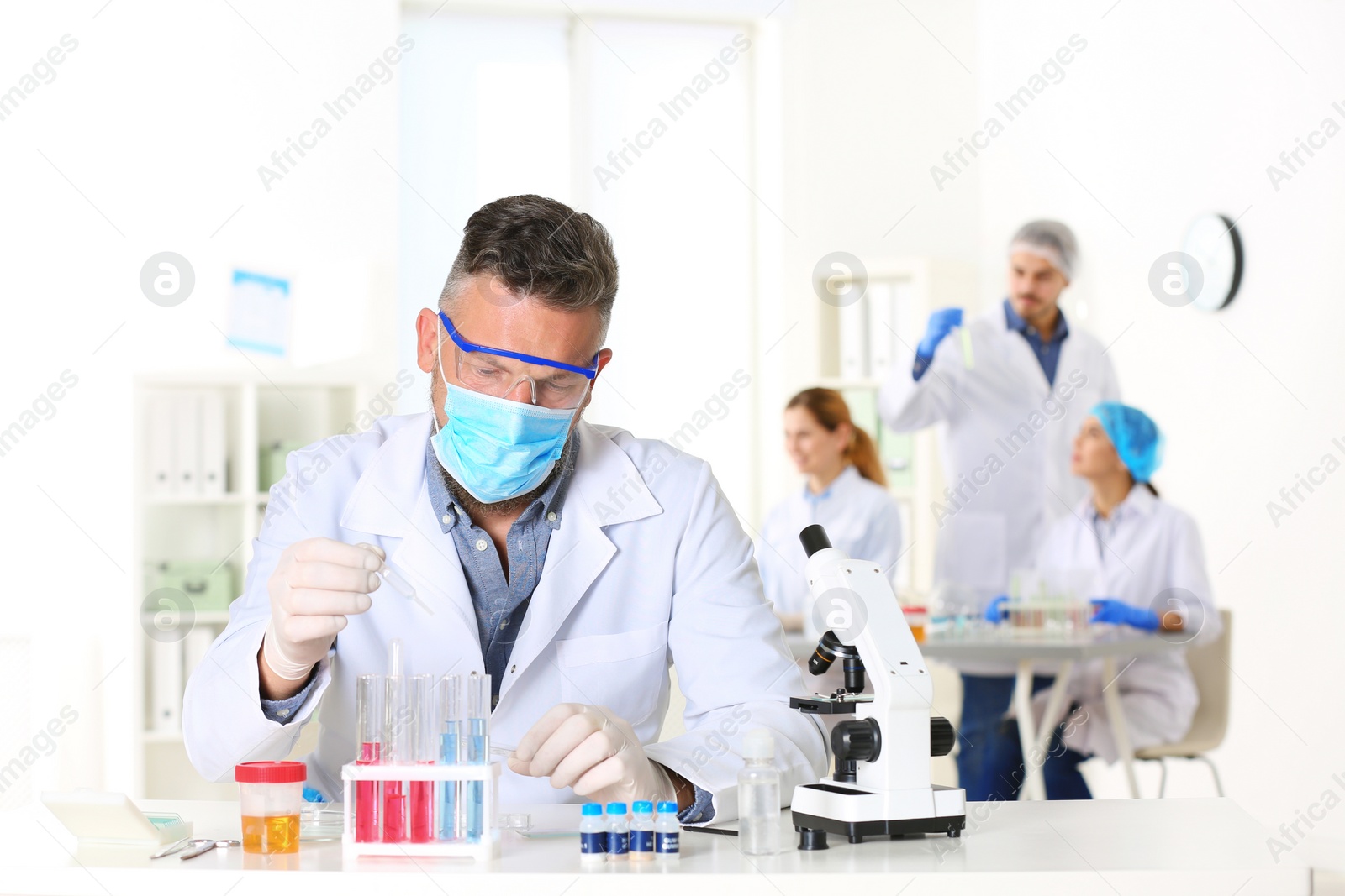 Photo of Male scientist working at table in laboratory, space for text. Research and analysis