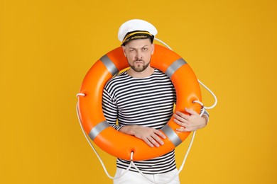 Serious sailor with orange ring buoy on yellow background