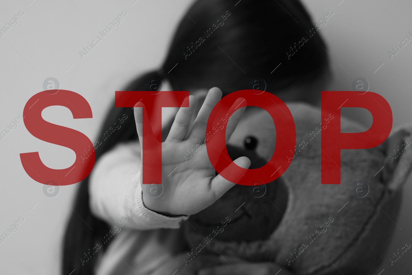 Image of No child abuse. Girl with toy making stop gesture, selective focus. Black and white effect