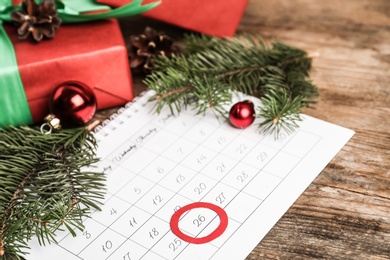 Calendar with marked Boxing Day date near gifts 
on wooden table, closeup