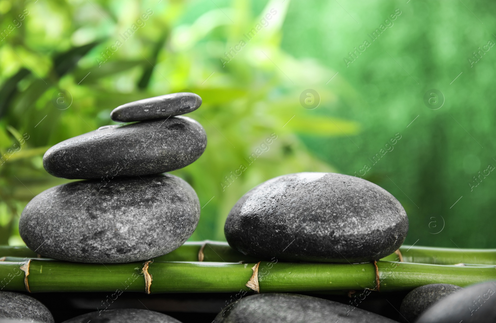 Photo of Zen stones on bamboo against blurred background